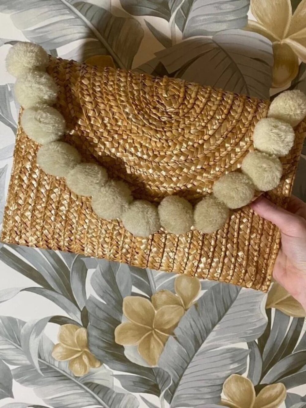 Straw woven clutch with white pom pom trim